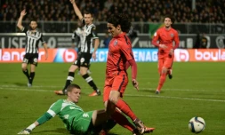 L'avant-centre du PSG Edinson Cavani bute sur le gardien Ludovic Butelle du SCO d'Angers au stade Jean-Bouin, le 1er décembre 2015