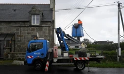 Un technicien d'Enedis raccorde des lignes électriques le 2 novembre 2023 à Lanildut, en Bretagne, après le passage de la tempête Ciaran 