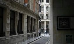 Un piéton solitaire marche dans une rue déserte de la City à Londres le 6 août 2020 pendant l'épidémie de coronavirus