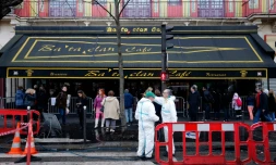 Des agents municipaux nettoient la façade et le trottoir devant le Bataclan à Paris, le 22 décembre 2015