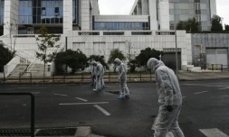 Des enquĂȘteurs de la police grecque recherchent des indices aprĂšs l'explosion d'un engin devant la cour de justice d'AthĂšnes, le 22 dĂ©cembre 2017