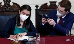 La présidente de la Convention constituante, Maria Elisa Quinteros (g), signe la dernière version de la nouvelle Constitution qui sera soumise à référendum, photographiée par son vice-président, Gaspar Dominguez, le 4 juillet 2022 à Santiago
