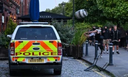 Un manifestant jette un fût de biÚre sur une voiture de police, à Bristol, le 3 août 2024