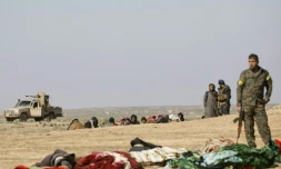 Un combattant des Unités de protection du peuple (YPG) kurdes attend le démarrage d'une fouille de prisonniers, prÚs de Baghouz, en février 2019