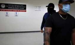 Des officiers en civil de la police fédérale de l'immigration (ICE) attendent dans un couloir d'un tribunal fédéral de l'immigration à New York le 6 juin 2025.
