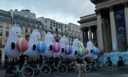 Des mascottes représentant la mouette "Boogi" se tiennent sur des vélos devant le Palais Brongniart à Paris, le 24 novembre 2023, pour marquer la candidature de la ville sud-coréenne de Busan à l'Exposition universelle de 2030