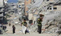 Des enfants portent du bois parmi les décombres dans le camp palestinien de Al-Shatee, dans l'est de la bande de Gaza, le 8 novembre 2025