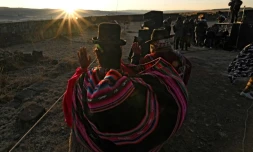 Des Indiens Aymaras lèvent les paumes au ciel pour recevoir les premiers rayons du soleil lors de la célébration du Nouvel An Aymara à Tiwanaku, en Bolivie, le 21 juin 2022