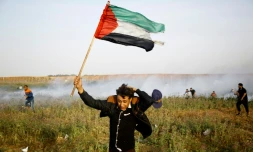 Un Palestinien brandissant un drapeau lors d'une manifestation à la frontière entre la bande de Gaza et Israël le 4 avril 2018
