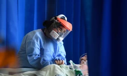 Une soignante réconforte un patient atteint par le Covid-19 dans un hôpital de Cambridge, le 5 mai 2020 au Royaume-Uni