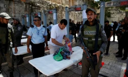 Un homme vide son sac après avoir traversé des portiques détecteurs de métaux, près de la Porte des Lions, l'une des principales entrées de la Vieille ville de Jérusalem, le 16 juillet 2017