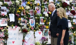 Le président américain Joe Biden et sa femme Jill Biden se recueillent devant un mur du souvenir en hommage aux 18 personnes décédées et aux 140 toujours portées disparues dans l'effondrement d'un immeuble, le 2 juillet 2021 à Surfside, en Floride