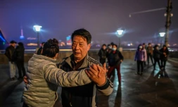 Un couple danse près du pont traversant le Yangtse à Wuhan, Chine, le 22 janvier 2021