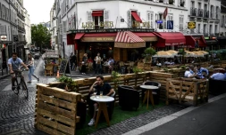 Des personnes prennent un verre à la terrasse élargie d'un bar à Paris, le 23 juillet 2020
