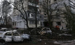 Des employés municipaux ukrainiens nettoient une rue de Dnipro dans la région centrale de Dnipropetrovsk après une frappe de drones russes le 7 janvier 2026 