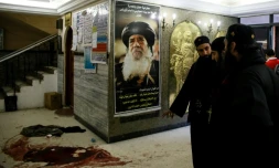 Des taches de sang maculent le sol près d'un poster de l'ancien pape copte égyptien Chenouda III après une attaque meurtrière contre une église près du Caire, le 29 décembre 2017
