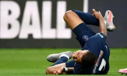 L'attaquant du Paris SG Kylian Mbappé se tient la cheville droite après avoir subi une faute lors de la finale de Coupe de France contre Saint-Etienne le 24 juillet 2020 au Stade de France à Saint-Denis