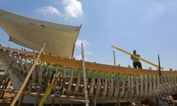 Le Syrien Khaled Bahlawan construit à la main un bateau en bois au bord de l'île d'Arwad, dans l'ouest de la Syrie, un artisanat que sa famille veut préserver, le 24 juillet 2022
