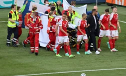 Les joueurs danois entourent la civière qui transporte Christian Eriksen hors du terrain après son arrêt cardiaque lors du match de l'Euro contre la Finlande le 12 juin 2021 à Copenhague