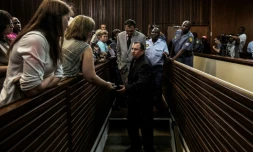 Willem Oosthuizen (C/G) et Theo Jackson (C/D), deux fermiers condamnés pour avoir tenté d'enfermer un homme noir dans un cercueil et menacé de le brûler, au tribunal de Middelburg, en Afrique du Sud, le 27 octobre 2017 