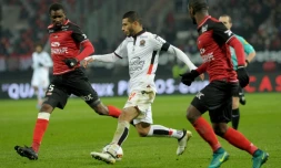 Le mileu de Nice Younes Belhanda (c) à la lutte avec les joueurs de Guingamp Moustapha Diallo (g) et Jordan Ikoko au Roudourou, le 30 novembre 2016