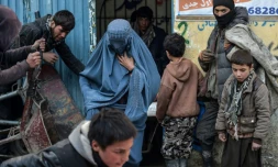 Des habitants font la queue pour recevoir de l'aide humanitaire devant le bureau d'une organisation caritative, le 30 janvier 2022 dans la banlieue de Kaboul