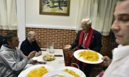 Le prêtre Angel Garcia (à droite) en compagnie de sans-abris pendant leur dîner au restaurant "Robin des Bois" de Madrid, le 1er décembre 2016