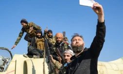 Des rebelles posent pour une photo sur un avion de l'armée syrienne dans la base aérienne de Kweyris, dans l'est de la province septentrionale d'Alep, le 3 décembre 2024 