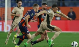 Le capitaine du PSG Kylian Mbappé (d) devance le défenseur de Montpellier Becir Omeragic (c), le 17 mars 2024 à Montpellier