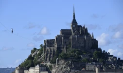 Le funambule Nathan Paulin sur une slackline de 2.200 mètres de long reliant une grue à l'abbaye du Mont Saint-Michel, le 24 mai 2022
