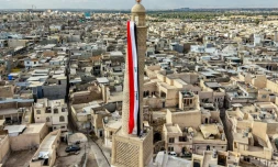 Un drapeau irakien géant est suspendu au minaret penché Hadba, datant du XIIᵉ siècle et reconstruit, dans la vieille ville de Mossoul, le 29 septembre 2026