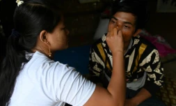 Pan Ei Phyu (g) soigne son mari Sai Ko (R), le 4 juillet 2020,  blessé dans un  glissement de terrain dans une mine de jade près de Hpakant