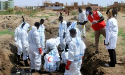 Des membres du Croissant-Rouge soudnais déterrent des dépouilles enterrées à la hâte durant la guerre, dans le quartier d'Al-Azhari dans la banlieue de Khartoum, le 2 août 2025 