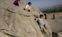 Des enfants de l'ethnie hazara jouent sur une falaise près des grottes où habitent des familles à Bamiyan le 3 octobre 2021