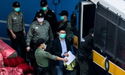 Le militant pro-démocratie Ben Chung (c) escorté par la police lors d'un transfert, le 2 mars 2021 à Hong Kong