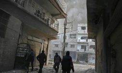 Des colonnes de fumée et de la poussiÚre s'élÚvent de la localité de Hammouriyé dans le fief rebelle de la Ghouta orientale prÚs de Damas, aprÚs un raid du régime, le 21 février 2018