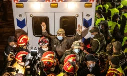 Des membres des forces de sécurité marocaines et des secouristes devant l'ambulance transportant le corps du petit Rayan après son extraction d'un puits à Ighrane, le 5 février 2022