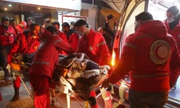 Des volontaires du Croissant rouge syrien évacuent un civil malade de Douma, ville rebelle assiégée près de Damas, tard le 28 décembre 2017