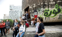 Des étudiants assistent, tournant le dos à "L'oeuf", une structure emblématique en béton au toit oblong à moitié en ruines, à un cours sur la politique des espaces publics à Beyrouth le 24 octobre 2019