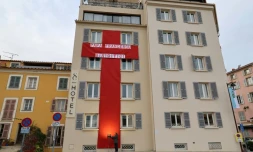 Une immense croix rouge en tissu accrochée à la façade d'un hôtel pour la visite du pape François à Ajaccio, le 12 décembre 2024 en Corse
