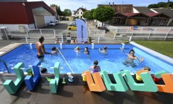 Des enfants prennent une leçon de natation dans une piscine itinérante fabriquée dans un ancien container, le 13 juillet 2022 à Hangenbieten, dans le Bas-Rhin