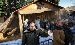 Milad Ayyad, un Palestinien chrétien orthodoxe de la bande de Gaza, devant une crèche sur le parvis de la basilique de la Nativité à Bethléem, en Cisjordanie occupée, le 26 décembre 2021