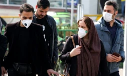 Des piétons, certains portant un masque de protection, dans une rue de Téhéran, le 22 février 2020 en Iran
