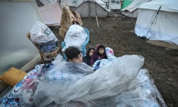 De jeunes Palestiniens sont assis sur des matelas recouverts de plastique dans un camp pour personnes déplacées à Rafah, dans le sud de la bande de Gaza, le 13 décembre 2023