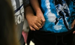 Deux enfants américains se tiennent le main à l'aéroport international de Miami avant de se rendre au Guatemala, le 4 décembre 2025 