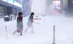 Des passants sur la 6e avenue en pleine tempête de neige à New York le 25 janvier 2026