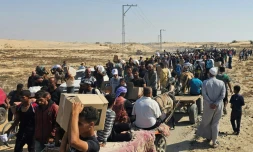 Des Palestiniens déplacés marchent le long d'une route pour recevoir des colis d'aide humanitaire d'un centre d'aide soutenu par les États-Unis à Rafah, dans le sud de la bande de Gaza, le 5 juin 2025