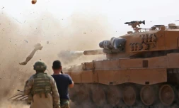 Des soldats turcs observent un char de leur armée tirer sur des positions d'une milice kurde, à Ras al-Aïn (nord de la Syrie), le 28 octobre 2019