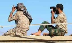 Des soldats libyens loyaux au gouvernement libyen d'union nationale (GNA) observent Syrthe alors qu'ils s'apprĂȘtent Ă attaquer cette ville tenue par l'EI, le 18 juillet 2016