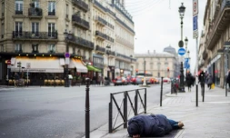 Un SDF dort le 16 janvier 2017 sur le trottoir à Paris où une vague de froid est attendue dans les prochains jours